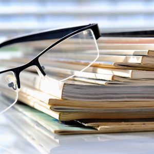 Stack of magazines with nerd glasses
